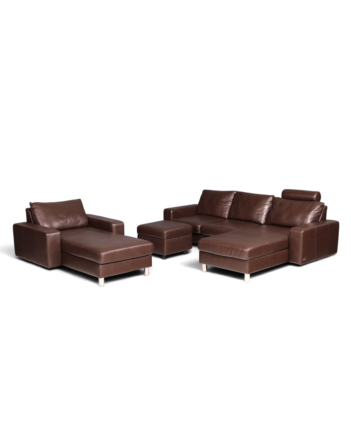 Hauptstadt Möblerei Stressless E200 Ledersofa Set in Braun mit Récamière, Longchair und Hocker auf grauem Hintergrund