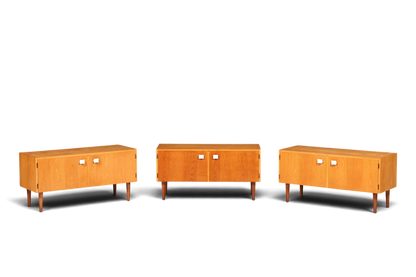 Hauptstadt Möblerei Hellerau Modell 427 Mid Century Sideboards aus hellem Holz mit weißen Griffen vor grauer Wand
